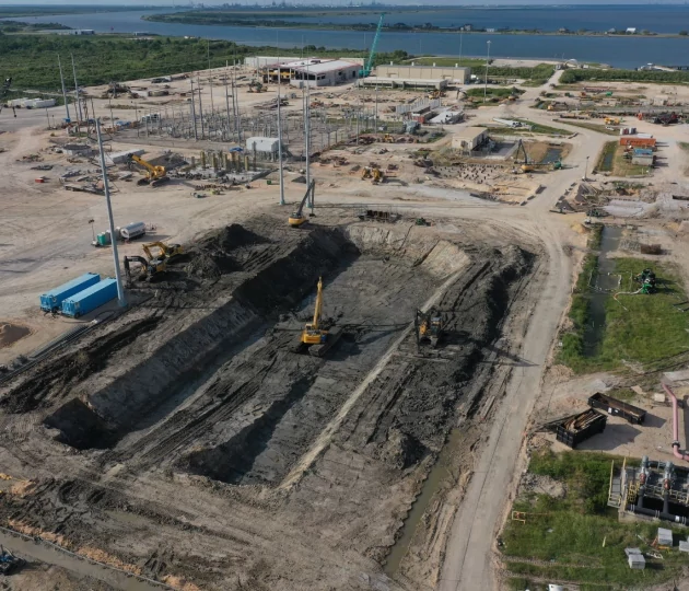 Aerial view of an excavation site with dug-out land pit and working equipment