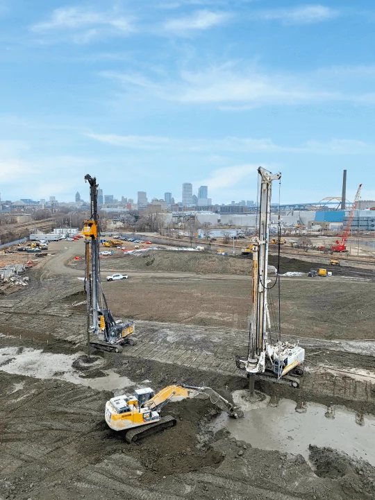 Project site with specialized equipment, two drilling machine rigs and one excavator