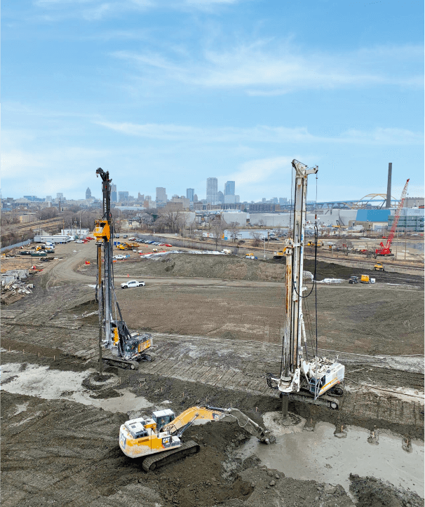 Project site with specialized equipment, two drilling machine rigs and one excavator