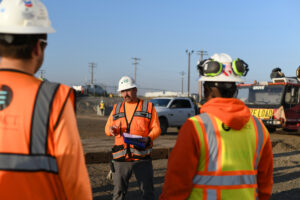 Site manager in safety gear leading safety meeting on project site