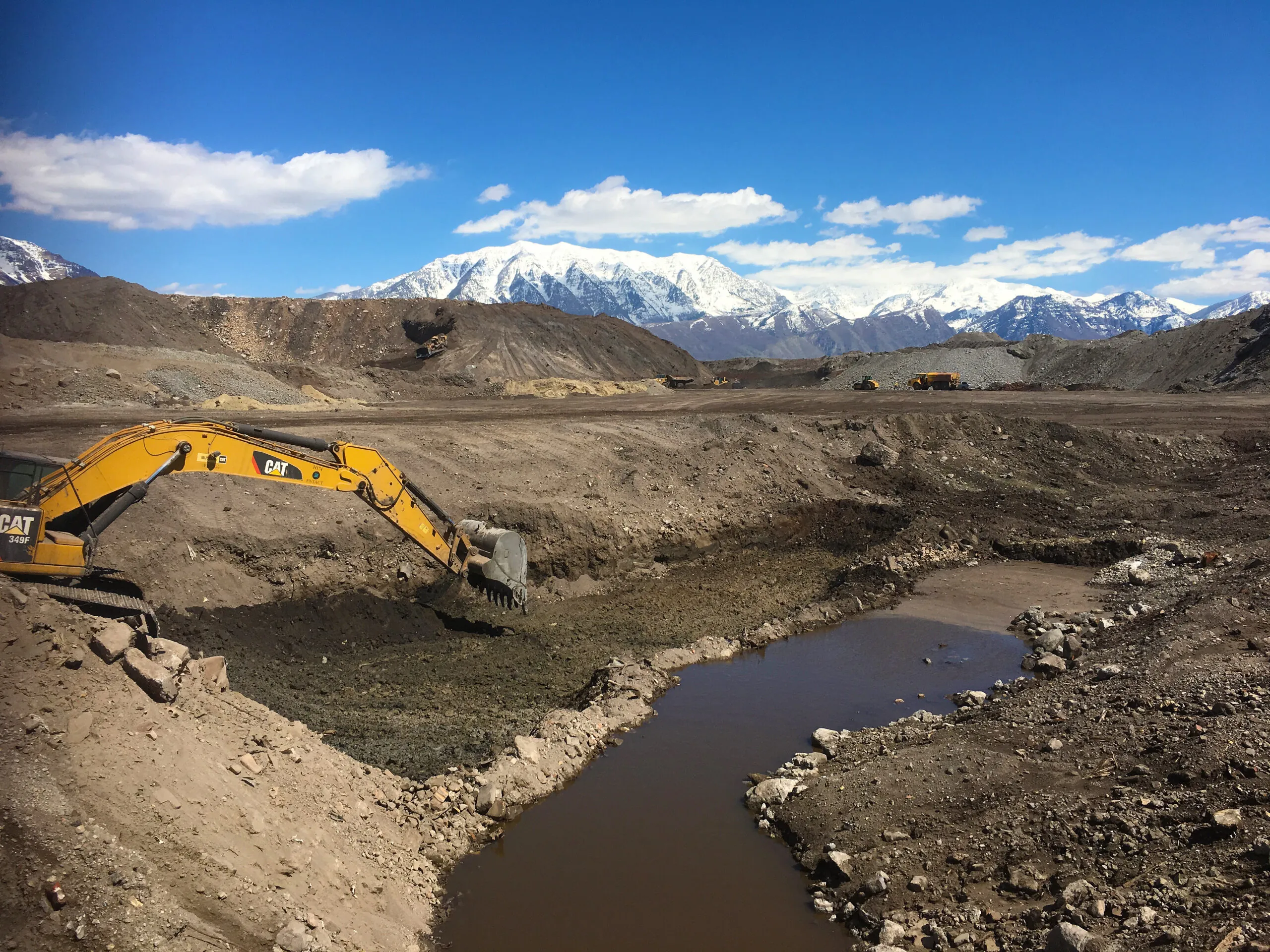 Backhoe digging at an environmental remediation project site.