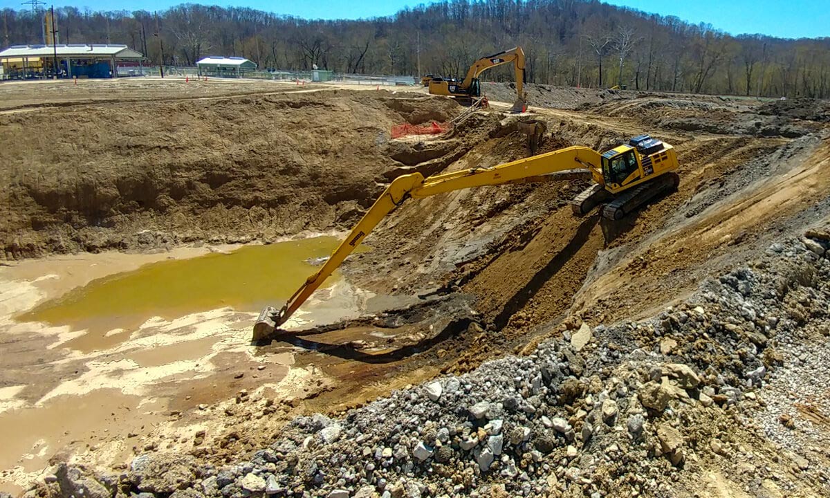 excavator digging out a trench with water in it