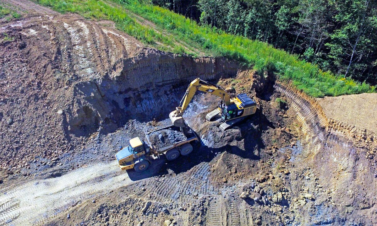 excavator digging hole for ground stabilization