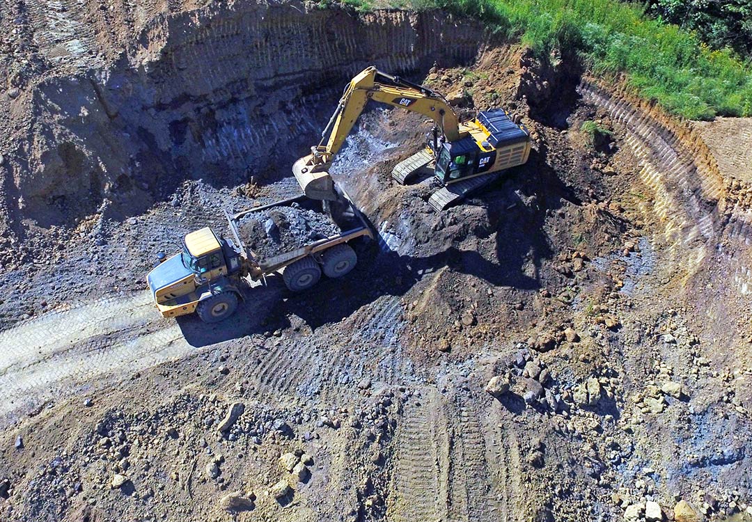 excavator digging hole for ground stabilization
