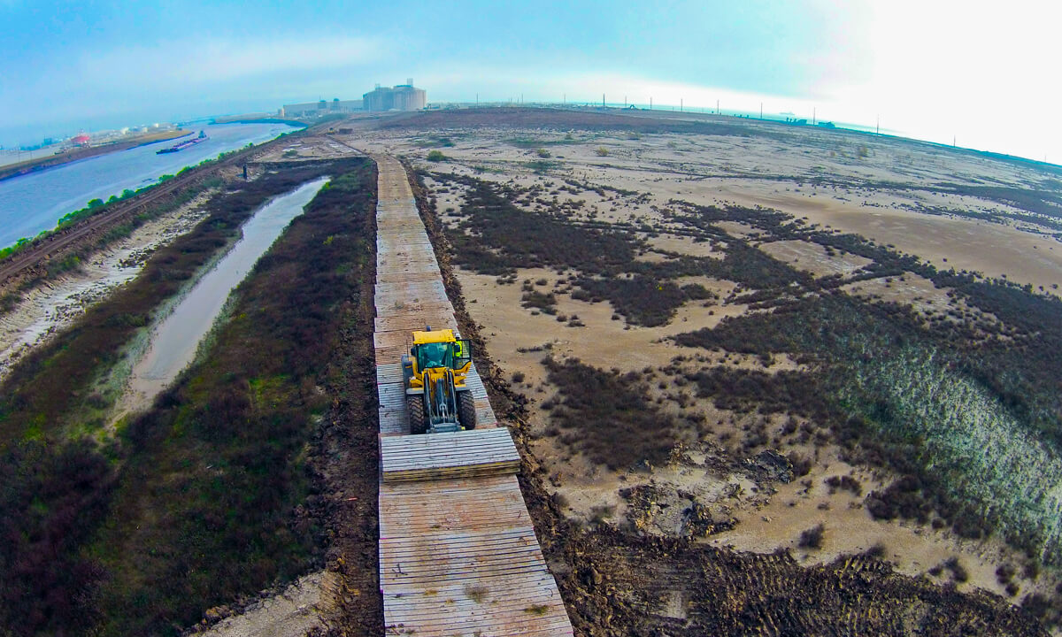 tractor driving in the middle of a large dirt lot